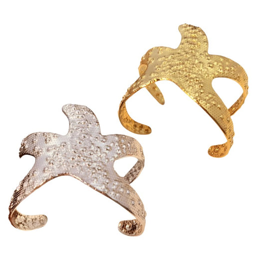 Starfish Bracelet - gold plated starfish cuff bangle by SIETE Y UNO
Two starfish-shaped gold and silver rings on a white background