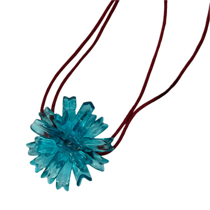 Blue Spider Flower Necklace - 3D printed resin pendant with crystal accents by SIETE Y UNO
Blue flower-shaped pendant on a red cord against a white background