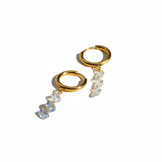 Gold hoop earrings with clear gemstones on a white background