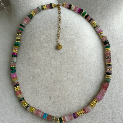 Necklace with multicolored beads on a mannequin neck against a neutral background