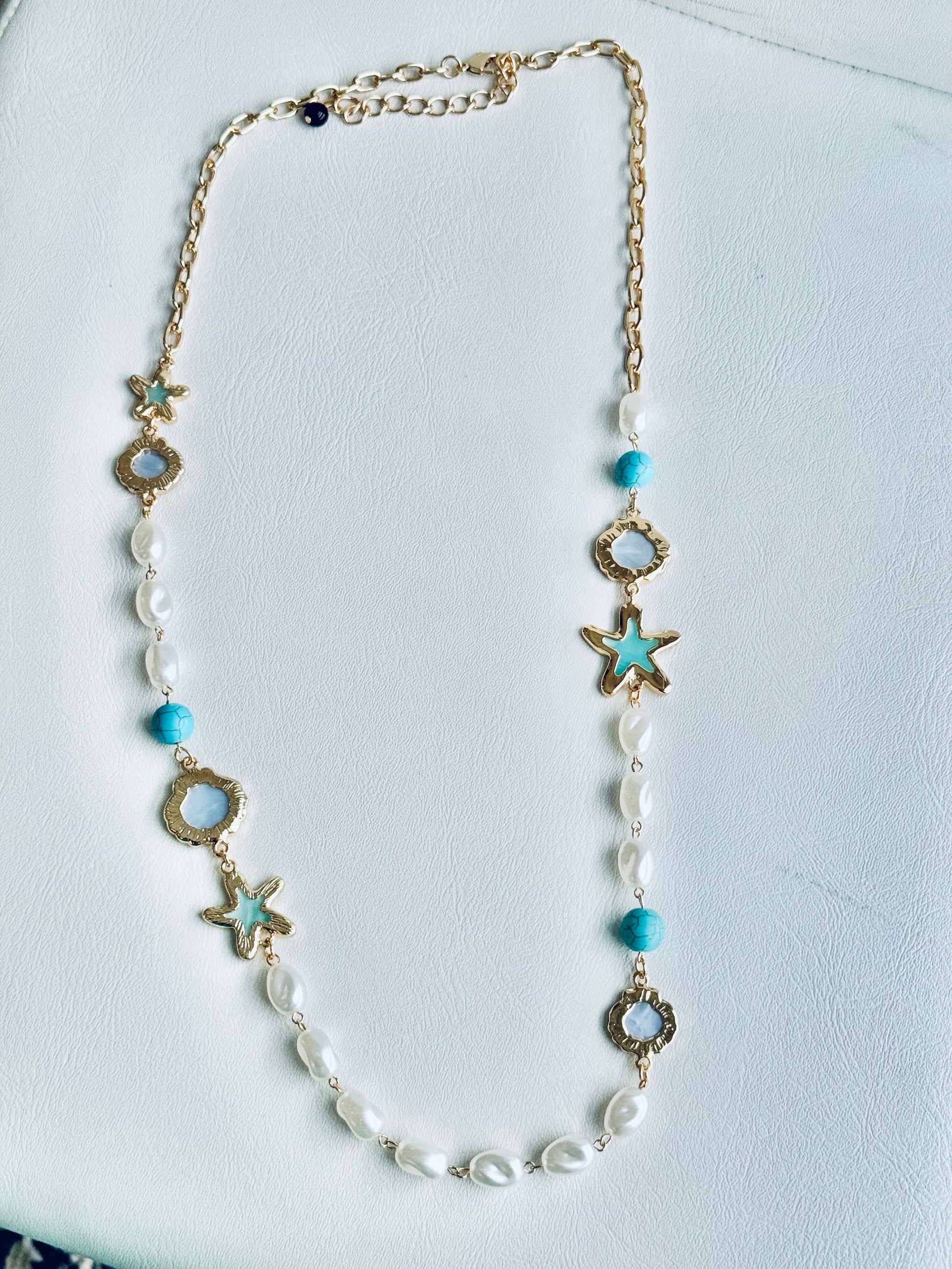 Eternal Star Necklace - close-up detail of star charm and chain
Necklace with star-shaped and circular beads on a white background