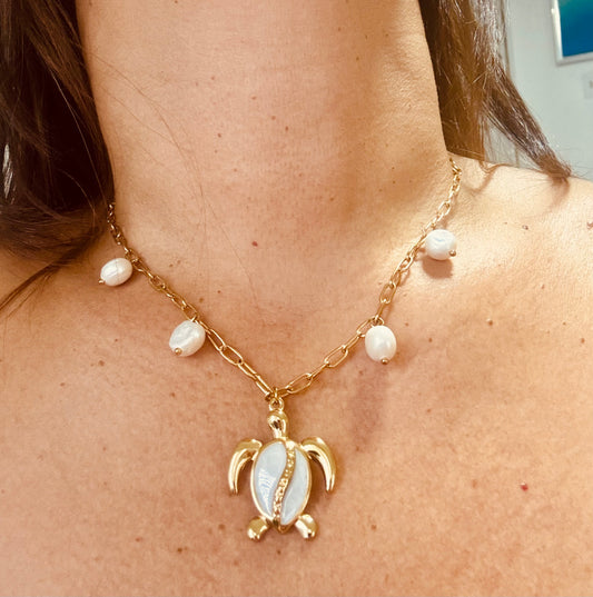 Necklace with turtle pendant and pearl beads on a person's neck