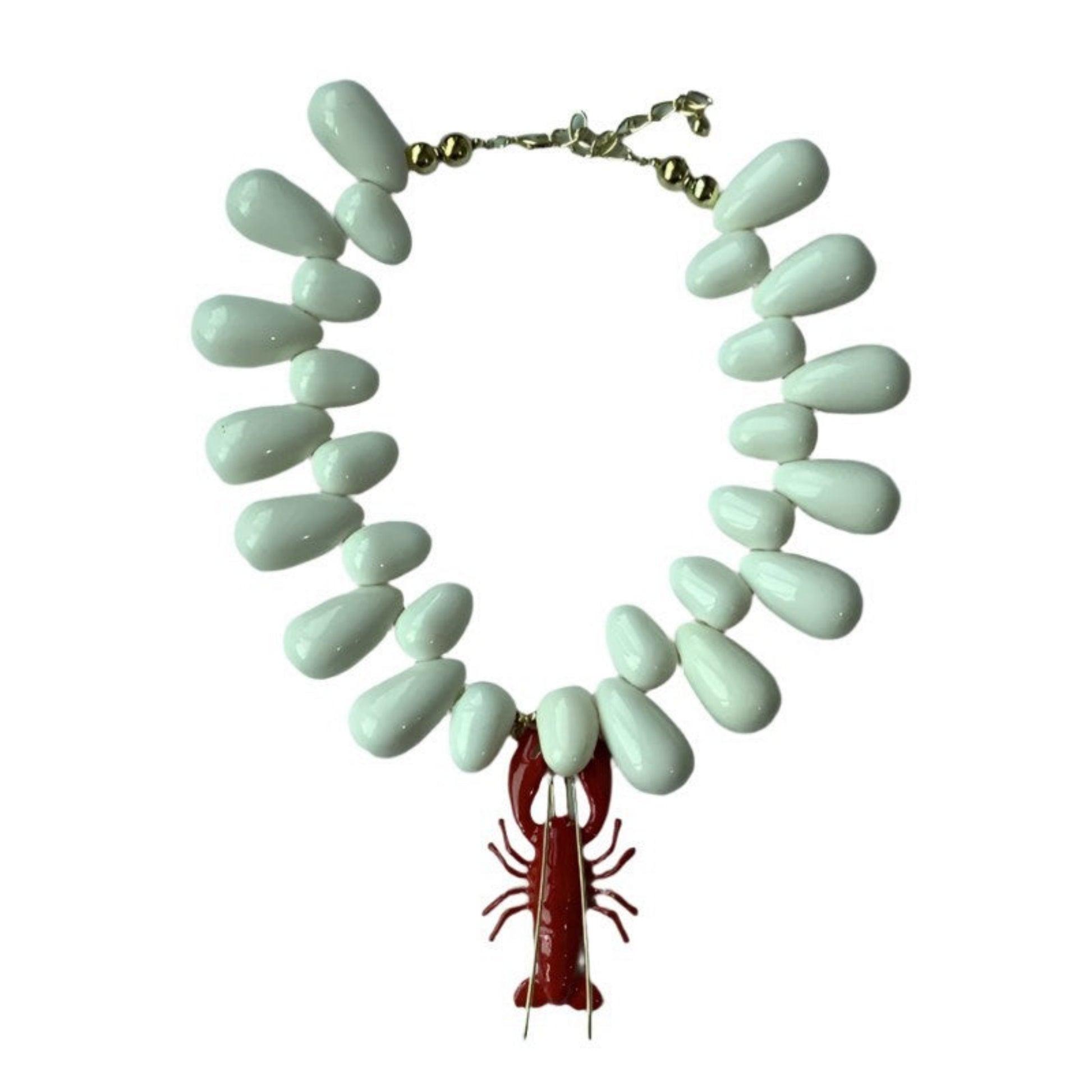 Necklace with light blue teardrop-shaped beads and a red lobster charm on a white background
Mystic Marine Necklace worn - Model wearing ocean-inspired pendant necklace in gold
