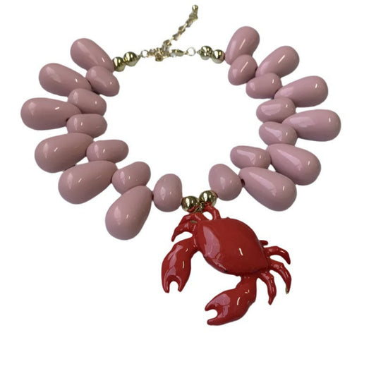 Necklace with pink teardrop-shaped beads and a red crab pendant on a white background