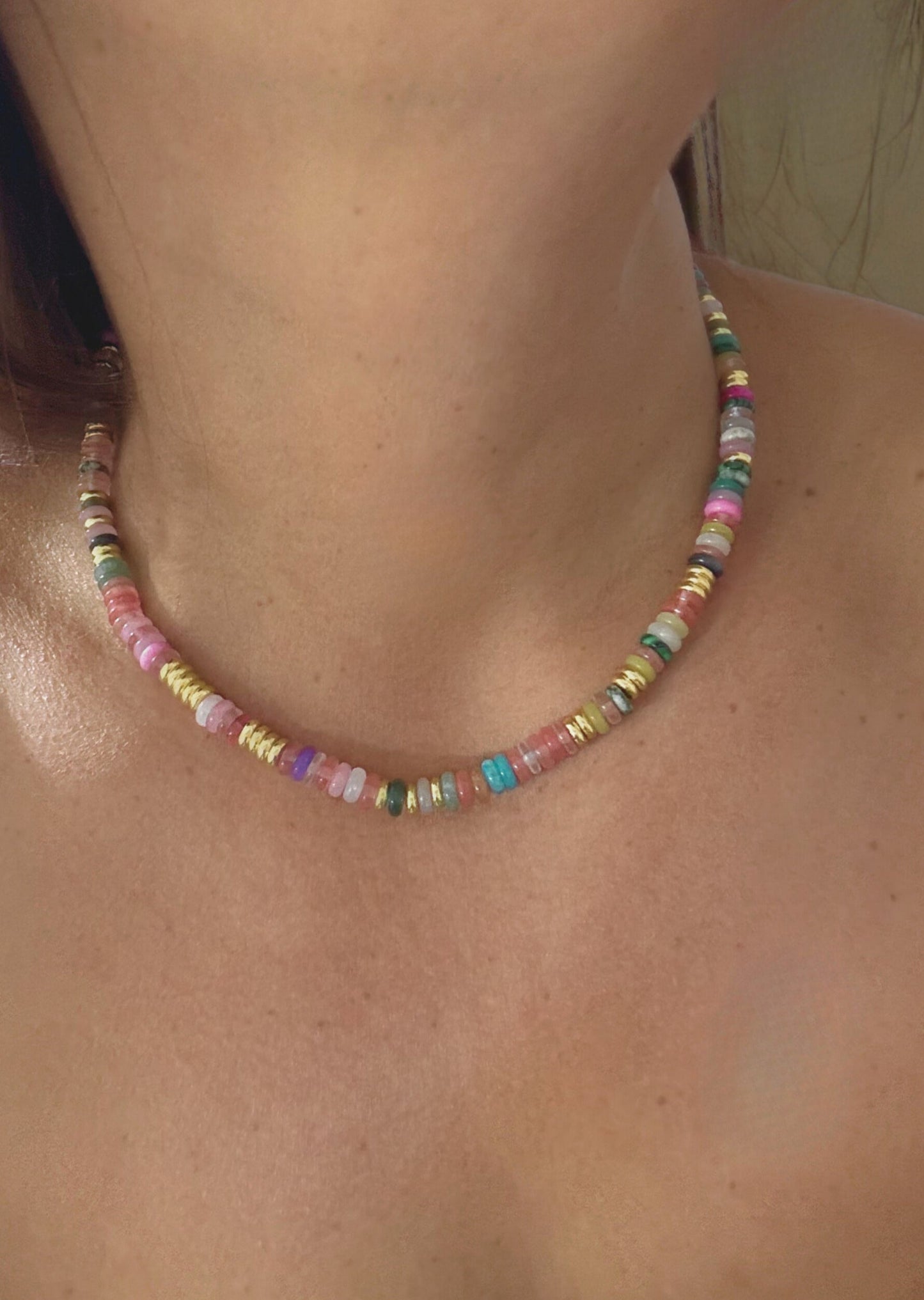 Memento Necklace - elegant pendant necklace by SIETE Y UNO
Close-up of a colorful beaded necklace on a person's neck.