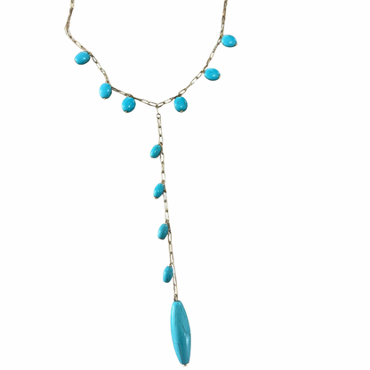 Necklace with blue beads on a white background
Nine Blue Necklace - Close-up detail of blue stone pendants and gold plating finish
