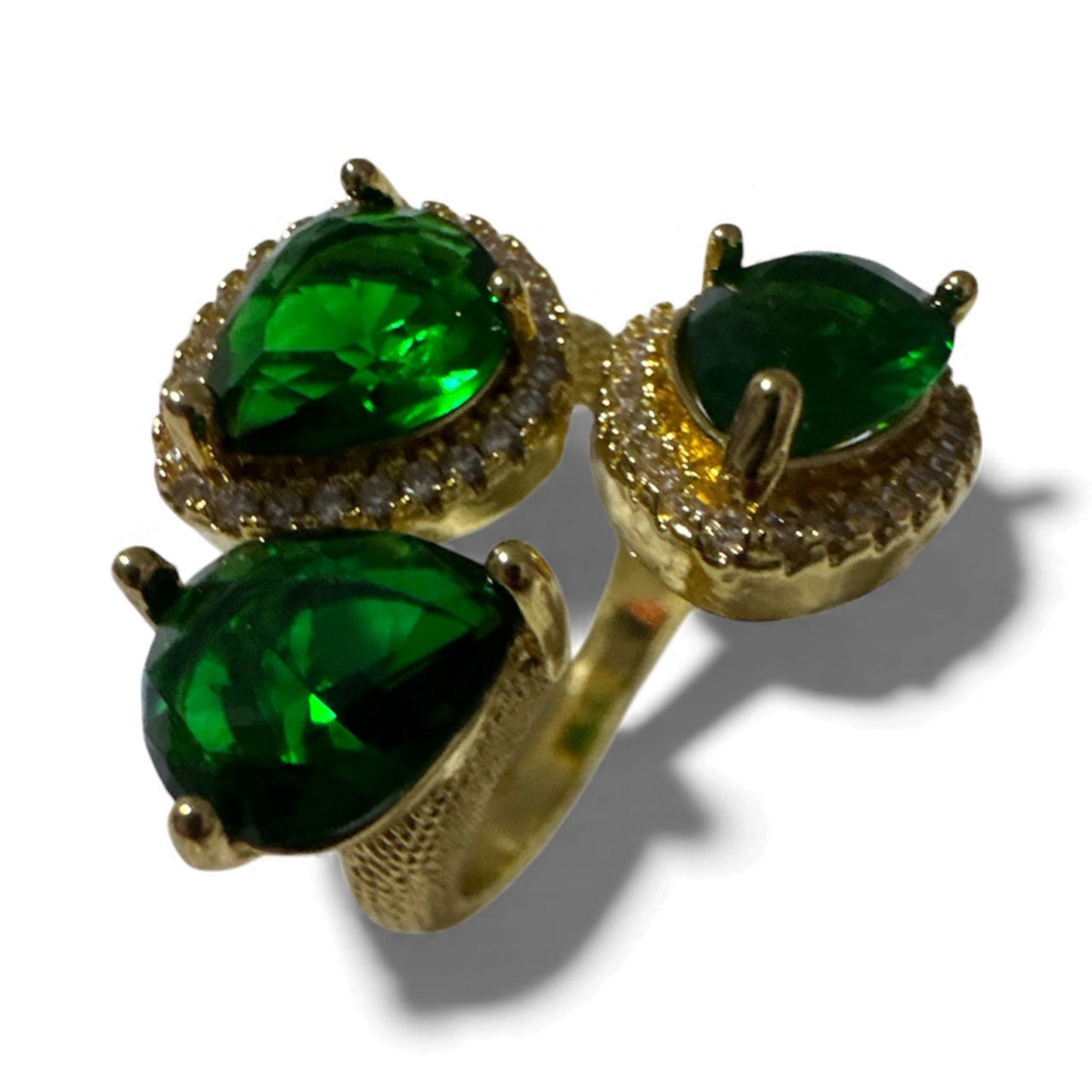 Gold ring with three green gemstones on a white background