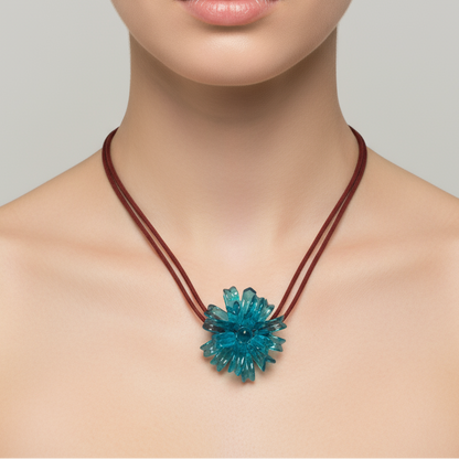 Blue Spider Flower Necklace worn by model - handcrafted resin jewelry from Puerto Rico
Necklace with a blue floral pendant worn by a model on a neutral background
